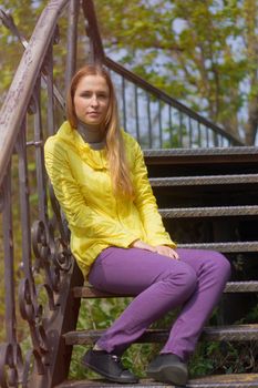 teenage girl sitting alone on the stairs.
