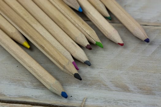 Close f of coloured pencils against a wooden background