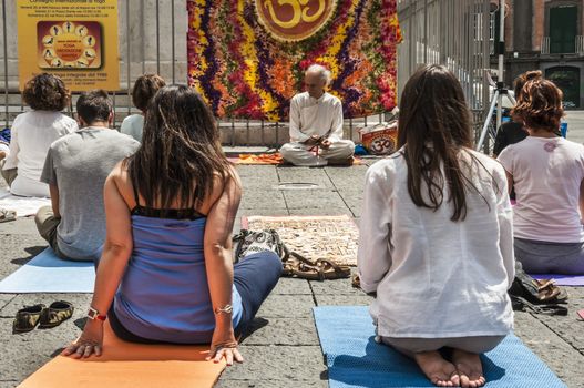 NAPLES - JUNE 21: people have yoga practice with a an expert and old man on the street on June 21, 2014 in Naples, Italy