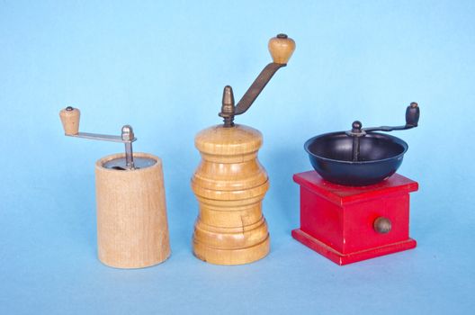 three spices pepper wooden vintage grinder on blue background