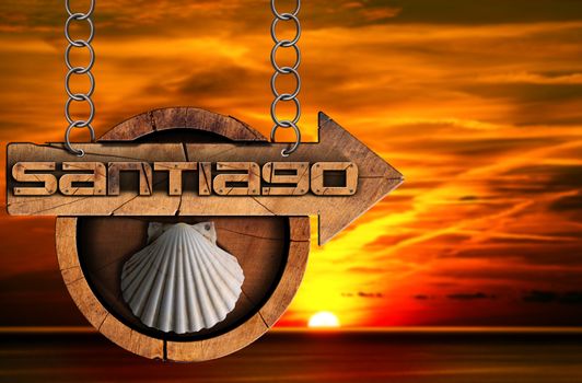 Pilgrimage wooden sign of Santiago de Compostela (Camino de Santiago) with an arrow and seashell. Hanging from a metal chain at sunset over the sea with cloudy sky
