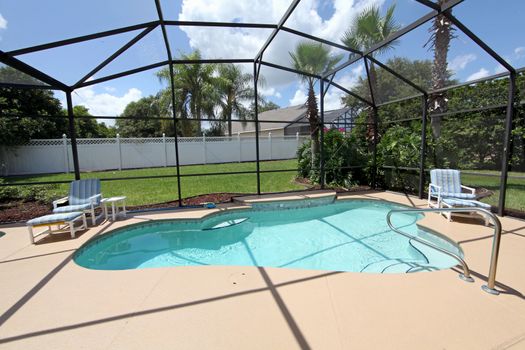 A swimming pool and deck with screen