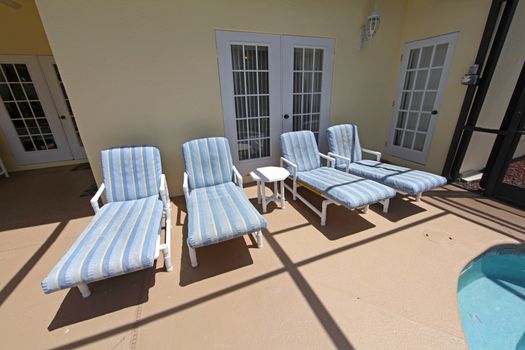 Four pool loungers in a pool area