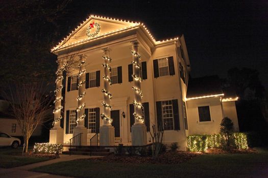 A Colonial House with a lot of Christmas Lights