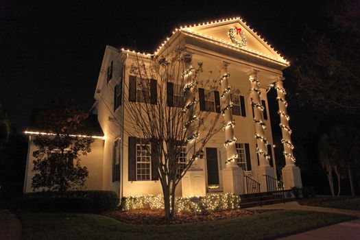 A Colonial House with a lot of Christmas Lights