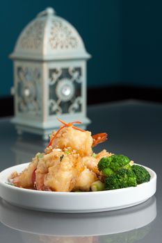 Thai style honey shrimp dish presented beautifully on a round white plate.