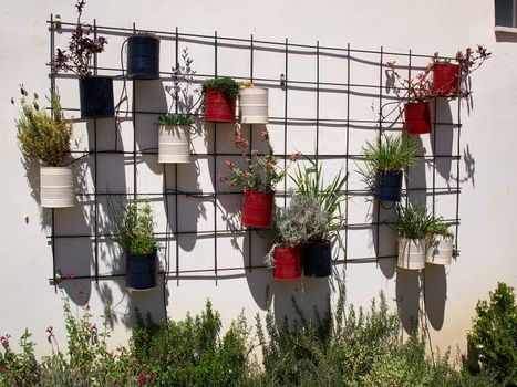 Typical wall planter pots  with flowers and plants hanged on a wall Tuscany Italy style               