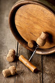 Cask with corks and corkscrew on a wooden table