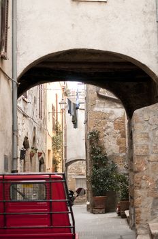 old red pickup truck parked in a street in stone in a medieval village