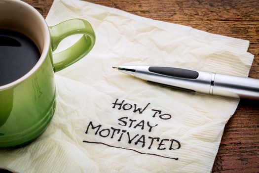 How to stay motivated - handwriting on a napkin with a cup of espresso coffee