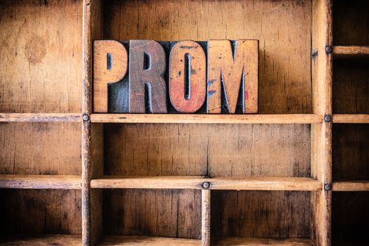 The word PROM written in vintage wooden letterpress type in a wooden type drawer.