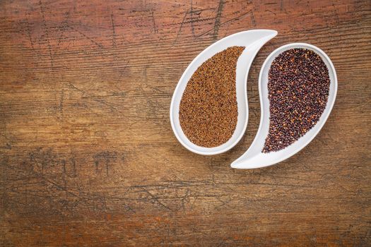 kaniwa and black quinoa  gluten free grains on on teardrop shaped bowls against rustic wood with a copy space