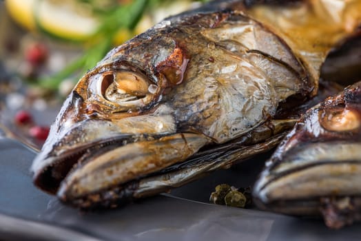 Baked Whole Mackerel Fish with Spice, Lemon and Rosemary on a Plate on Wooden Table