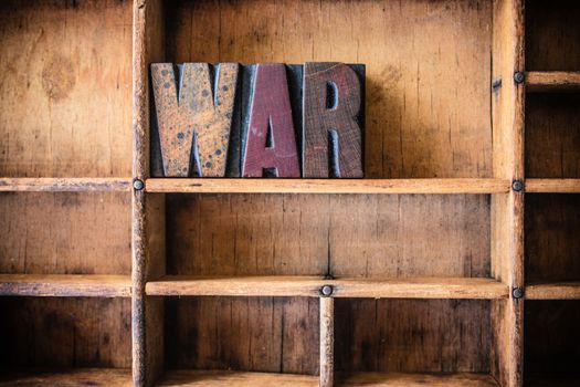 The word WAR written in vintage wooden letterpress type in a wooden type drawer.