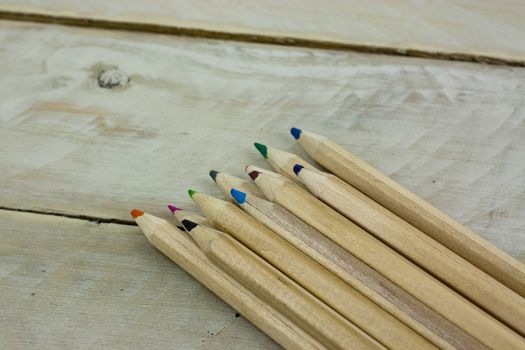 Close f of coloured pencils against a wooden background