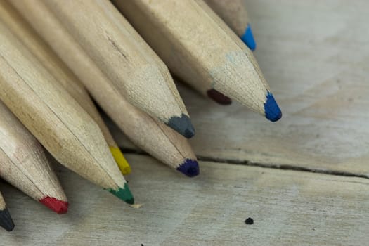 Close f of coloured pencils against a wooden background