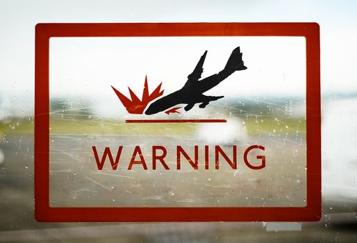 A Red Airport Security Warning Sign With Crashing Plane