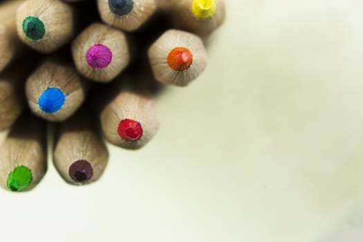 Close f of coloured pencils against a wooden background