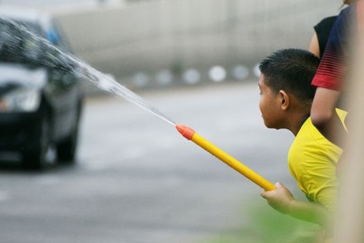 CHIANGMAI,THAILAND-APRIL 14, 2011: The boy with water pressure gun in a water fight festival or Songkran Festival (Thai New Year), on April 14, 2011 in Chiangmai, Thailand.