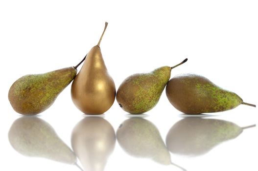 Golden pear standing out amongst row of fruit over a white background