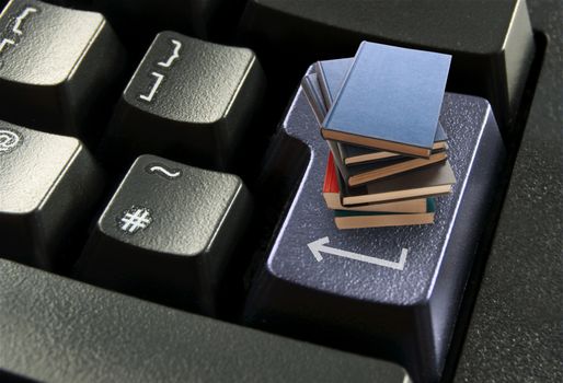 Stack of books on top of a computer enter key
