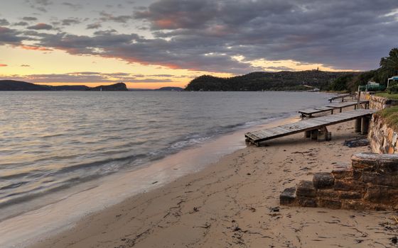 Timber boat ramps and sandstone steps at Palm Beach Pittwater at sunset.