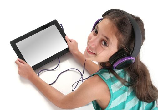 Beautiful pre-teen girl on the floor, usin a tablet computer and headphones, clipping path for the screen