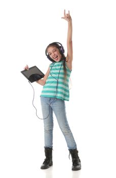 Beautiful pre-teen girl dancing and going crazy using a tablet computer and headphones