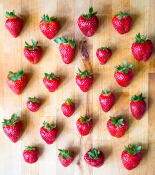Arranged strawberries on a wooden board
