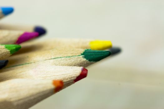 Close f of coloured pencils against a wooden background