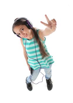 High angle picture for a beautiful pre-teen girl using a tablet computer and headphones. White background