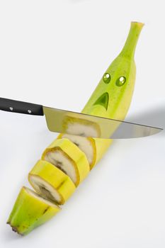 Picture of a banana that is sliced by a knife