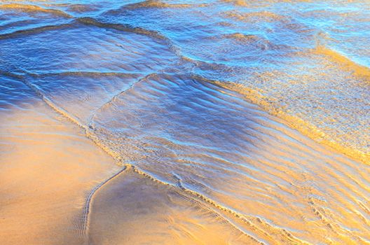 Surface waves on the sandy beach