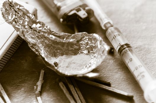 Drug syringe and cooked heroin on spoon