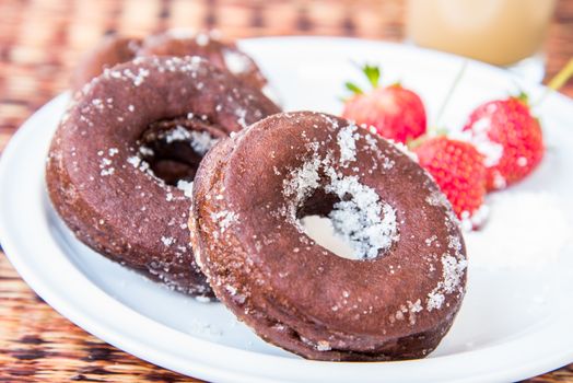 Sugar chocolate donuts and fresh strawberries and ice coffee