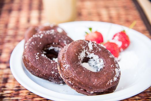 Sugar chocolate donuts and fresh strawberries and ice coffee