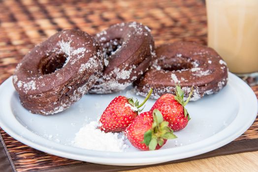 Sugar chocolate donuts and fresh strawberries and ice coffee