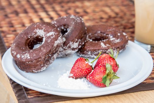 Sugar chocolate donuts and fresh strawberries and ice coffee