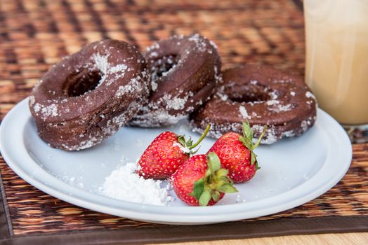 Sugar chocolate donuts and fresh strawberries and ice coffee