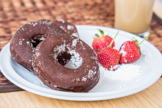 Sugar chocolate donuts and fresh strawberries and ice coffee