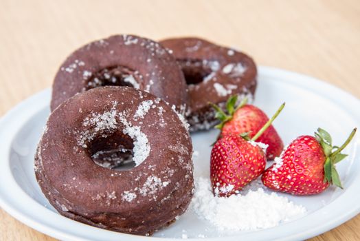 Sugar chocolate donuts and fresh strawberries and ice coffee