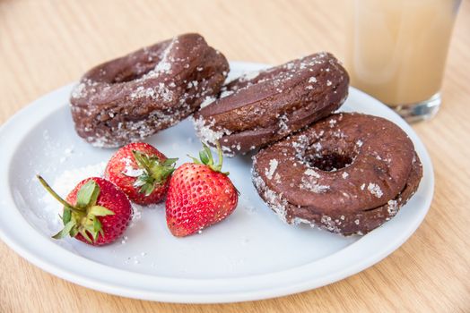 Sugar chocolate donuts and fresh strawberries and ice coffee