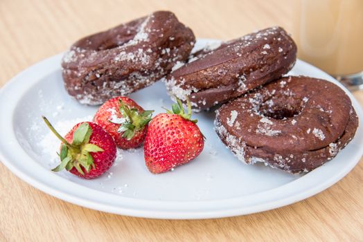 Sugar chocolate donuts and fresh strawberries and ice coffee