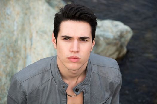 Headshot of attractive young man outdoor looking up at camera Headshot of attractive young man outdoor looking up at camera