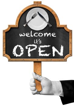 Hand of waiter with glove holding a pole and blackboard with text, Welcome it is open, white plate and silver cutlery. Isolated on white background