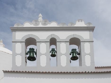 three copper bells in clock tower from catholic church in loule