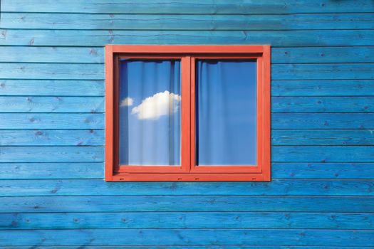 Modern colorful architecture. Wooden blue facade and red window  under blue sky