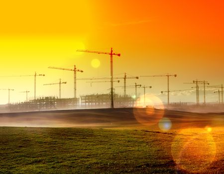 Sunset landscape.Construction cranes and buildings