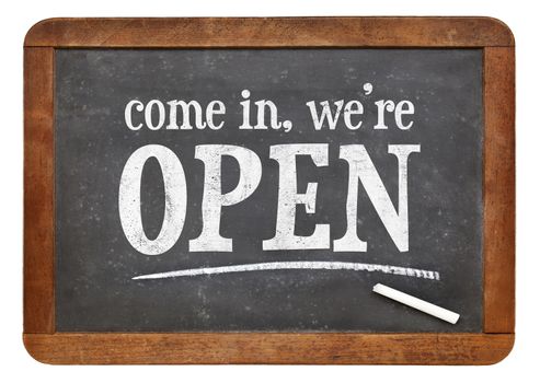 Come in, we are open - invitation on a vintage slate blackboard
