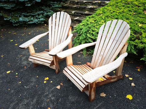 Two empty wooden chairs in autumn garden.